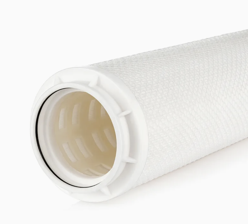 An engineer logging data on a clipboard next to a high flow filter housing