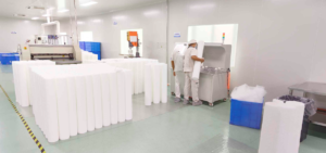 A large high-flow filter cartridge shown next to a standard-sized filter cartridge for scale