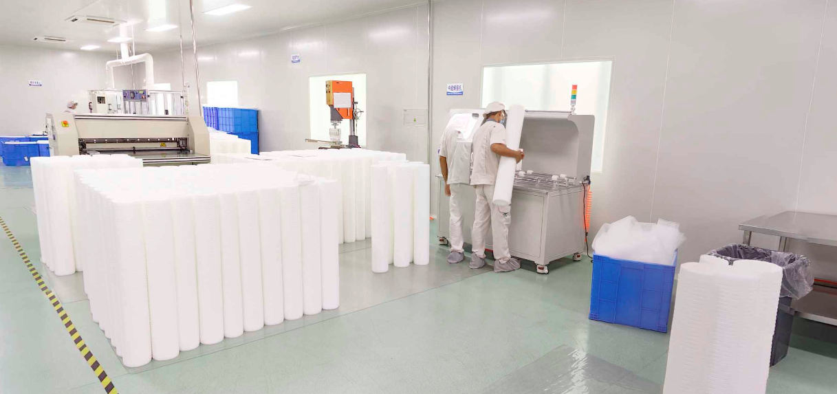 A large high-flow filter cartridge shown next to a standard-sized filter cartridge for scale