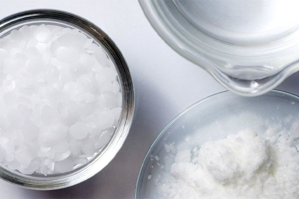 A magnified image showing cracked and degraded adhesive at the seam of a filter cartridge end cap after chemical exposure