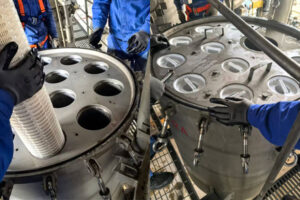 A technician replacing a clogged high-flow filter cartridge in a desalination plant